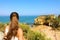 Traveler woman enjoying and relaxing stunning view of Southern Portugal. Back view of beautiful girl in her travel in Lagos