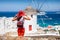 Traveler woman enjoys the view to a traditional Greek windmill in Mykonos