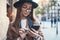 Traveler woman in hat hold in hands mobile phone. Closeup smartphone technology internet online. Girl tourist in glasses