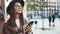 Traveler woman in hat hold in hands mobile phone. Smartphone technology internet online. Girl tourist in glasses using gadget
