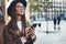 Traveler woman in hat hold mobile phone. Closeup smartphone technology internet online. Girl tourist in glasses using gadget