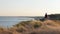 Traveler woman hitchhiking on a sunny ocean sea beach and walking. Young happy backpacker woman looking for a ride to