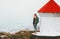 Traveler woman and lighthouse at foggy sea