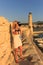 Traveler woman photographer with professional camera takes shot of Rethymno,Crete, Greece