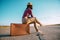 Traveler woman sits on suitcase on road