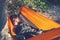 Traveler woman sleeping in a hammock on a rocky seashore