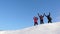 Travelers come to the top of a snowy hill and enjoy the victory against the blue sky. teamwork and victory. teamwork of