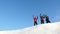 Travelers come to the top of a snowy hill and enjoy the victory against the blue sky. teamwork and victory. teamwork of