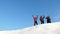 Travelers come to the top of a snowy hill and enjoy the victory against the blue sky. teamwork and victory. teamwork of