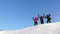Travelers come to the top of a snowy hill and enjoy the victory against the blue sky. teamwork and victory. teamwork of