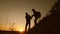 Travelers descend from mountain at sunset, hold hands. adventure and travel concept. teamwork of business people. Hiker