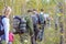 Travelers make their way through a dense forest, tourists with backpacks in the forest