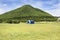 Travelers people build tent camping on grass field for rest and sleep near mountain