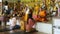 Travelers sit near Buddhist monks conducting special ritual