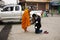 Travelers thai women travel visit and respect praying put food and things offerings to monks on the road front of local market