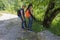 Travelers travel on the road in mountains go trekking together. Nature background. Group of tourists hitching a ride