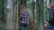 Travelers trekking forest in summer time. Woman and man hiking between trees