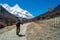 Travelers walking with snow capped mountain background to Milk Lake and Five colors lake in Yading Nature Reserve