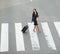 Traveling businesswoman crossing street