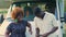 Traveling in camper concept. Two black people in their late 20s standing in front of their big white old-fashioned van