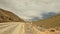 Traveling by car in Kyrgyzstan. An exciting road adventure. Road serpentine. View of a dirt rocky road.