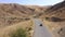 Traveling by car. A red car is moving along a mountain road in Kyrgyzstan.