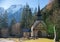 Traveling. A church in the depths of a forest. Alpine mountains on the background