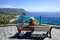 Traveling in Italy. Panoramic view of fashion girl sitting on bench in Capo Vaticano viewpoint on the Coast of the Gods, Calabria