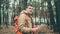 A traveling man with map in woods. A portrait of the handsome man with a backpack, standing near a tree in a cold