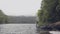 Traveling man standing on tree falling in river water in tropical forest on green highlands background. Young man