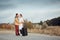 Traveling man and woman with a suitcase on an empty road, travel concept