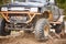 Traveling off-road on dirty off-road on a black and orange truck. Close-up of the wheel, suspension in a puddle and mud