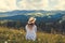 Traveling in summer Ukraine. Trip to Carpathian mountains. Woman tourist sitting in flowers admiring view