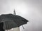 Traveling tourist with black umbrella in chelsea Manhattan on a wet and dreary rainny day at Madison Square park in new york city