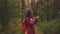 Traveling woman with dreadlocks with a phone in woods. Female traveler with backpack in woods reading map on a