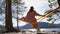 Traveling woman in a hat is resting in an orange hammock. beautiful view of the river and mountains. Norway telemark