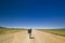 Traveller with backpack on a lonely road in desert