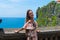 Traveller girl enjoy amazing view one of the most popular tourist attractions island Bali balinese hindu Uluwatu Temple