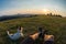 Traveller and his dog sitting in the grass and watching the suns