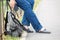 Traveller legs in jeans and hand with cellphone, man resting and sitting steel fence, backpack laying on ground