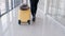 A traveller with a suitcase is going through an airport hall