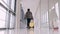 A traveller with a suitcase is going through an airport hall