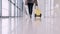 A traveller with a suitcase is going through an airport hall