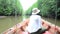 Traveller thai woman sit on long tail boat for looking and travel view riverbank