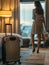 Traveller woman with luggage in business hotel guest room looking out toward city view staying for work travel or vacation trip