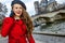 Traveller woman near Notre Dame de Paris talking on smartphone