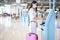 A traveller woman is wearing protective mask in International airport, travel under Covid-19 pandemic, safety travels, social