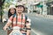 Travellers couple smiling on camera while sitting on motorbike