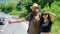 Travellers try to stop car. Couple hitchhikers travelling summer sunny day. Couple travelers man and girl hitchhiking at