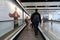 Travellers Walk on a Moving Walkway in an Airport